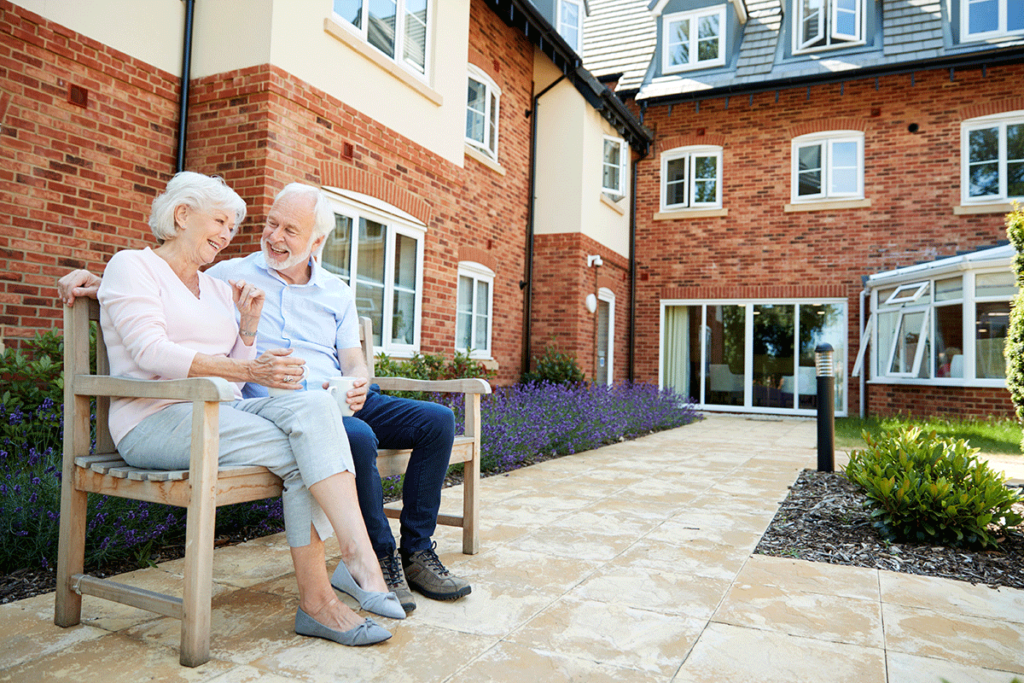 a couple of seniors enjoy senior living amenities, like an outdoor patio