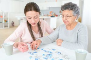 young woman helping elderly relative determine how to choose the right memory care facility