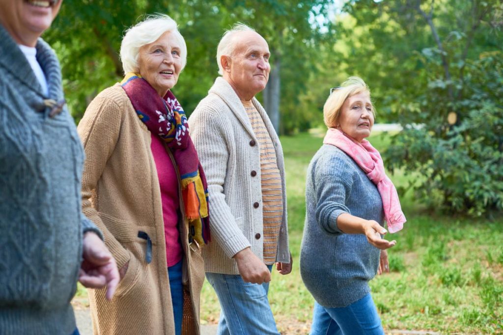 three senior citizens walking together outdoors and discussing how much is respite care per week day and hour