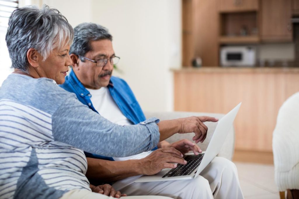 elderly couple looking at brochure to determine the senior lifestyle expenses to expect in assisted living