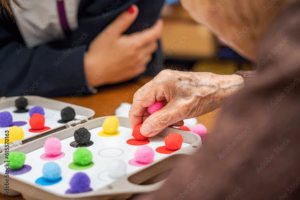 a senior does one of many activities for seniors with dementia with a caregiver