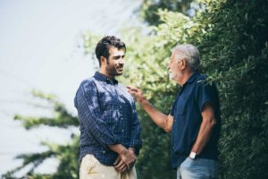 middle-aged son confronting his father on front lawn because he does not know what to do when senior parent refuses to move to assisted living