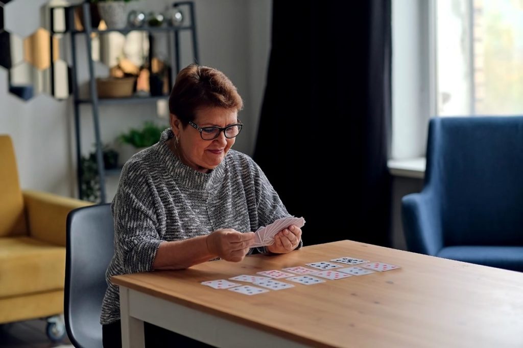 Senior woman playing card game to improve memory