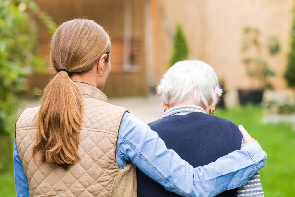 image of middle-aged woman helping her elderly parent while wondering is dementia hereditary