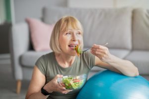 older woman enjoying a healthy salad displaying the importance of nutrition for elderly