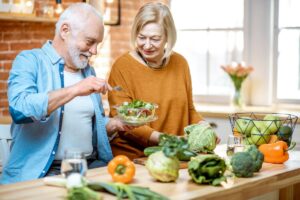 a couple prepares healthy summer foods for senior citizens