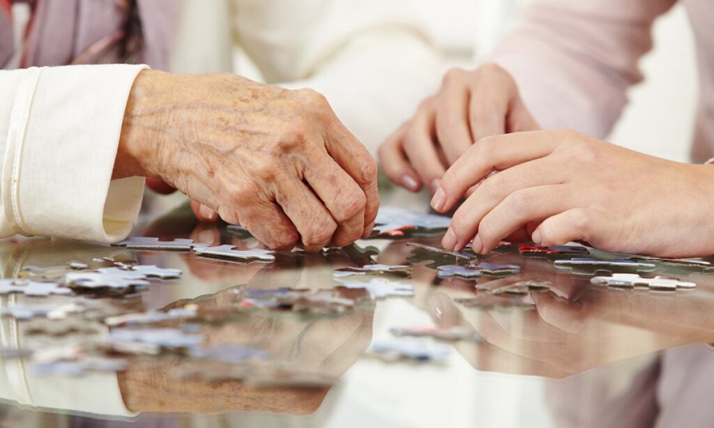 people put together a puzzle which provides good sensory stimulation for dementia patients