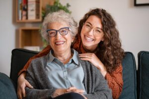 an adult child and senior parent smile after finding Longview long-term care