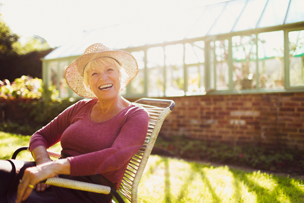 a senior woman happily relaxes outside